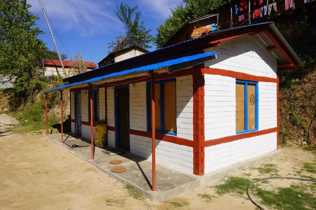 Uploaded project image of a small white house with blue trim.